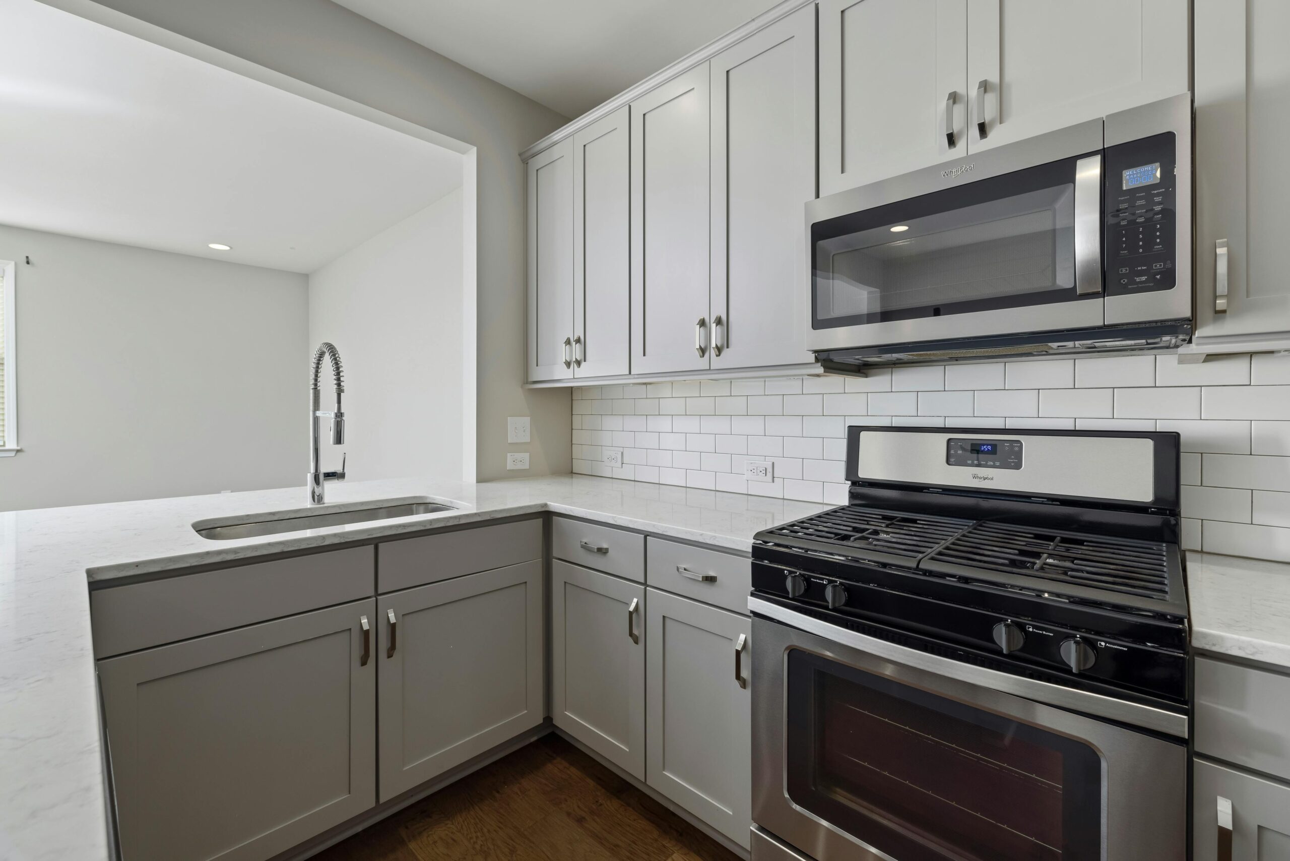 Stylish Kitchen with White Cabinets and Stainless Steel Appliances in Ada