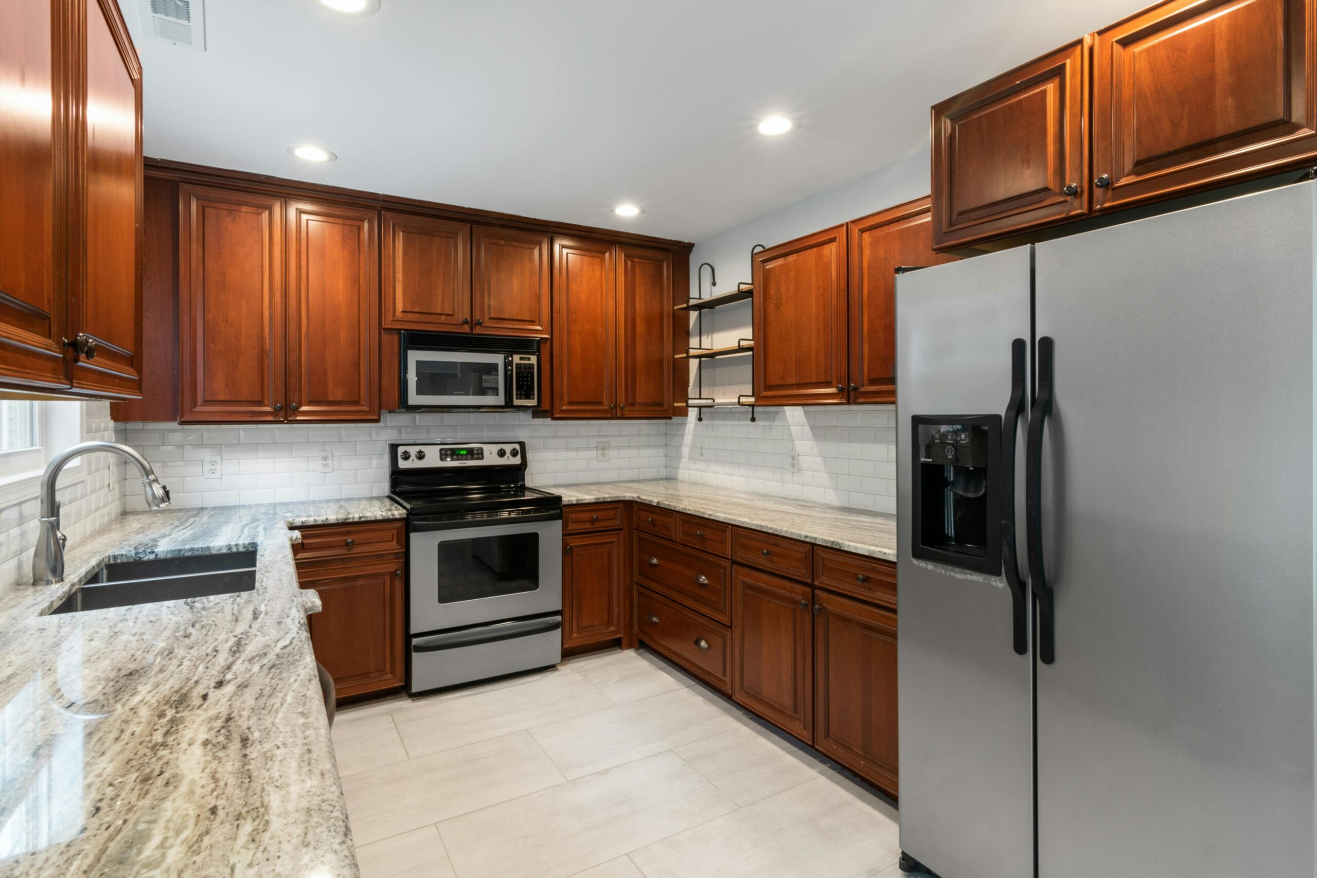 Stylish kitchen remodel with granite countertops, wood cabinets, and stainless appliances in Pontiac