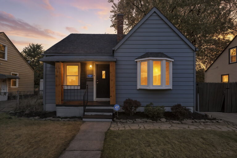 Remodeled blue house in Warren with new bay window and wood porch posts by Remodeling Warriors.
